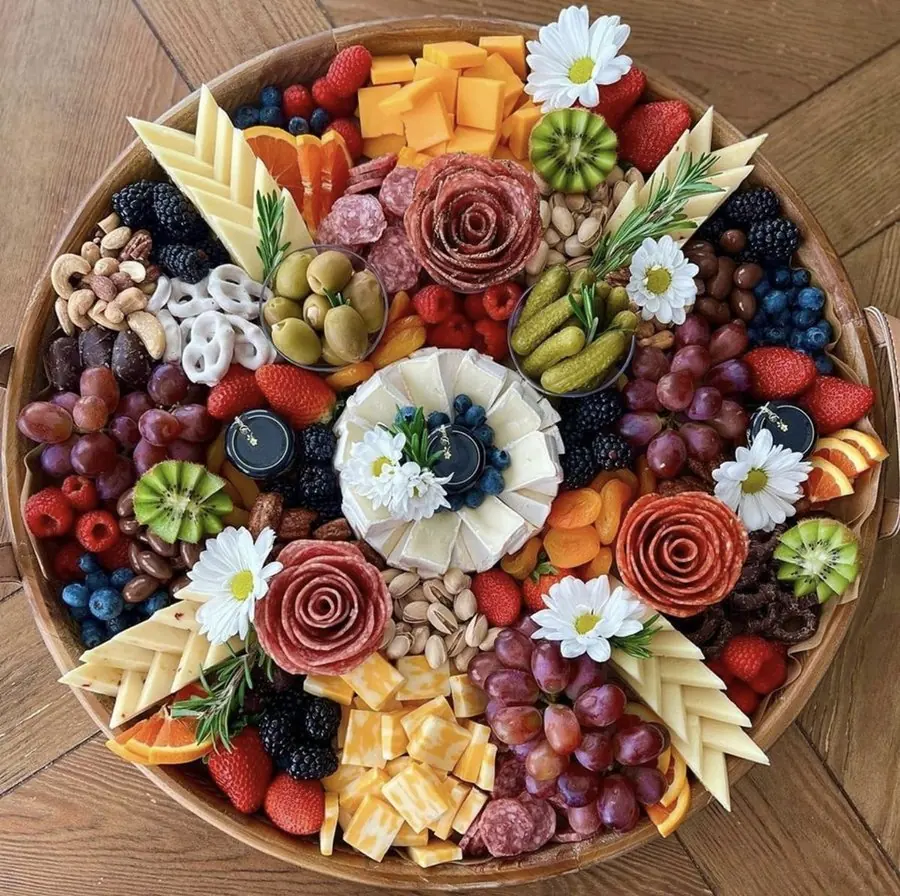 Artisan charcuterie board with cheeses fruits and flowers